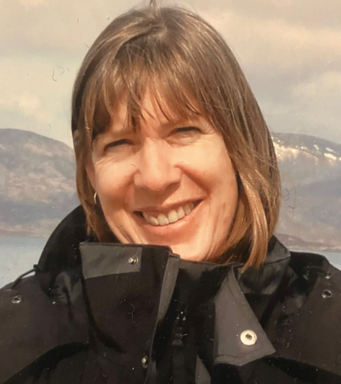 portrait of a woman with brown blonde hair wearing a black winter coat