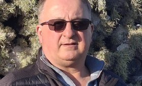 portrait of a man wearing sunglasses and dark grey coat